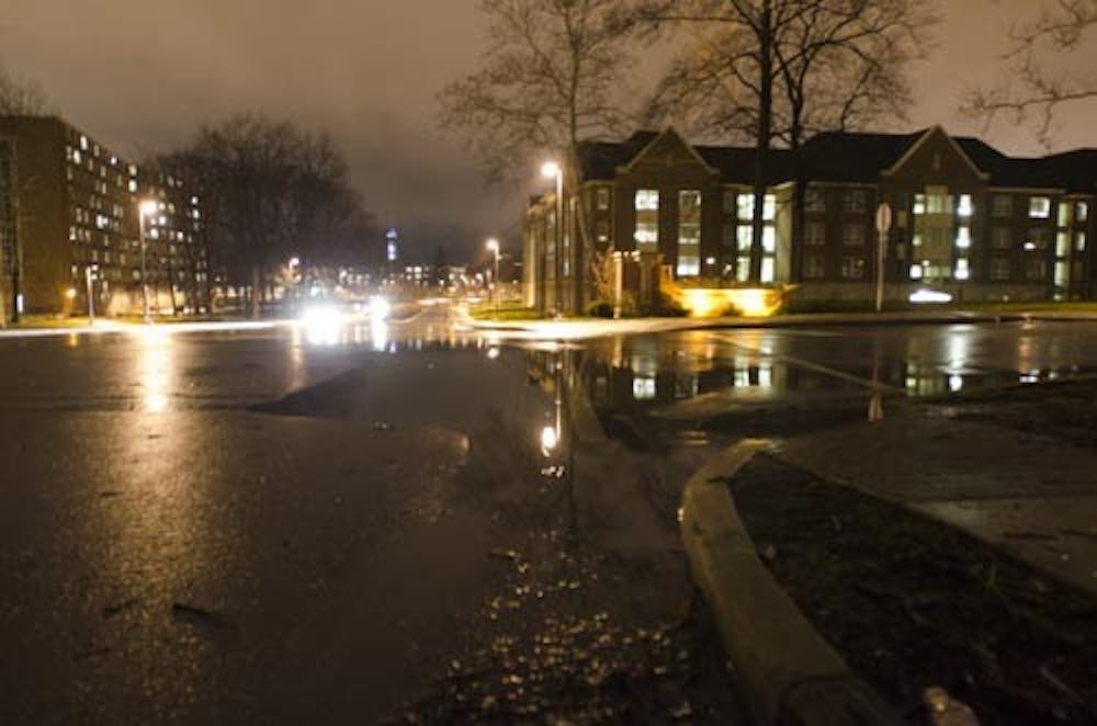 Water pools at the corner of Neely and New York avenues after steady rain took place over the weekend. Below-freezing temperatures are set to freeze much of the water that has been settling into low lying areas around campus. DN PHOTO COREY OHLENAKMP