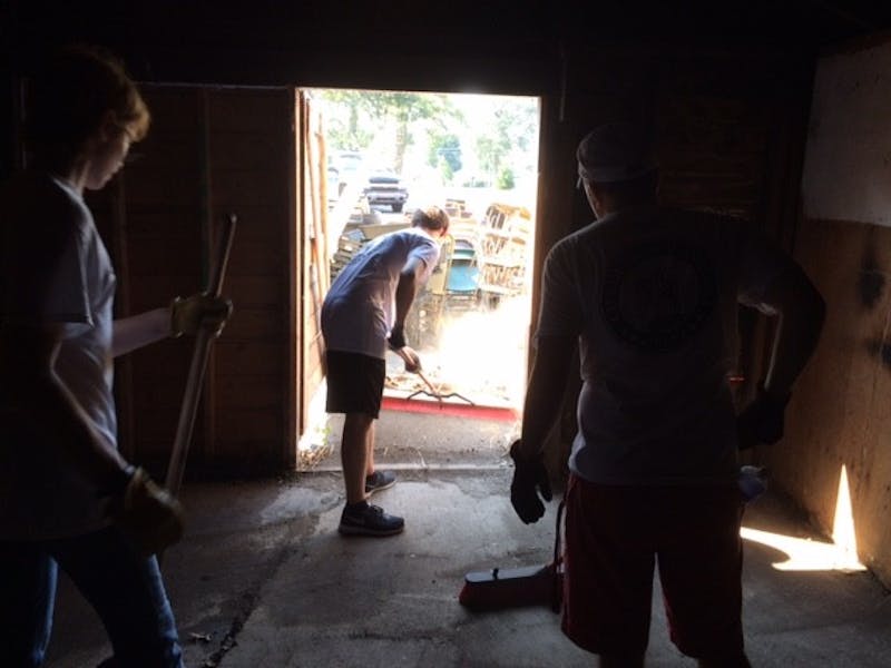 Brady Conner, 17, helps sweep a shed to contribute to the United Way Day of Action. PHOTO BY MICHAEL KUHN