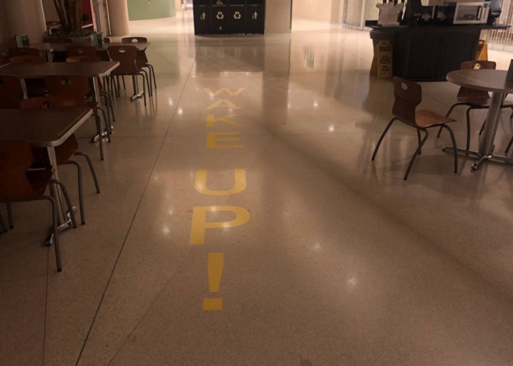 A Ball State art student put up several vinyl stickers in the Atrium Tuesday morning for an art project. The stickers ask people to "WAKE UP" to global warming and other Earth harming trends.