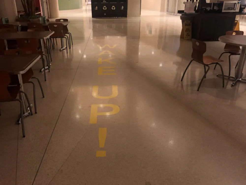A Ball State art student put up several vinyl stickers in the Atrium Tuesday morning for an art project. The stickers ask people to "WAKE UP" to global warming and other Earth harming trends.