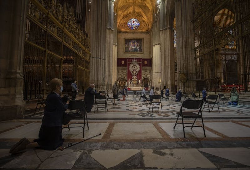 Catholic worshippers pray inside Seville's cathedral, Spain, Monday, May 11, 2020. Roughly half of 47 million Spaniards are stepping into a softer version of the country's coronavirus strict confinement and are beginning to socialize, shop in small establishments and enjoy a meal or a coffee in restaurants and bars with outdoor seating. (AP Photo/Miguel Morenatti)