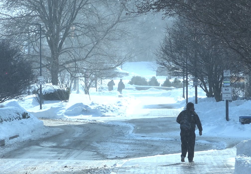 Students walk through the snow outside the Art and Journalism Building on Ball State University campus.