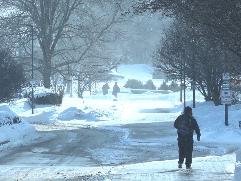 Students walk through the snow outside the Art and Journalism Building on Ball State University campus.