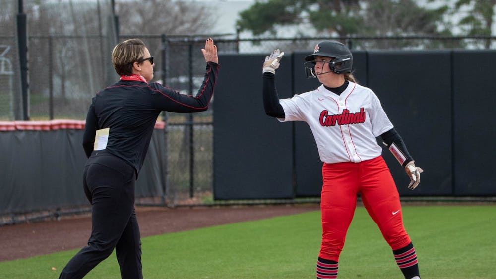 Head coach Lacy Wood celebrates with sophomore infielder Haley Wynn after a hit that got three runners to home March 26, 2021, at the Softball Field at First Merchants Ballpark Complex. The Cardinals won 8-6 against the Falcons. Jaden Whiteman, DN