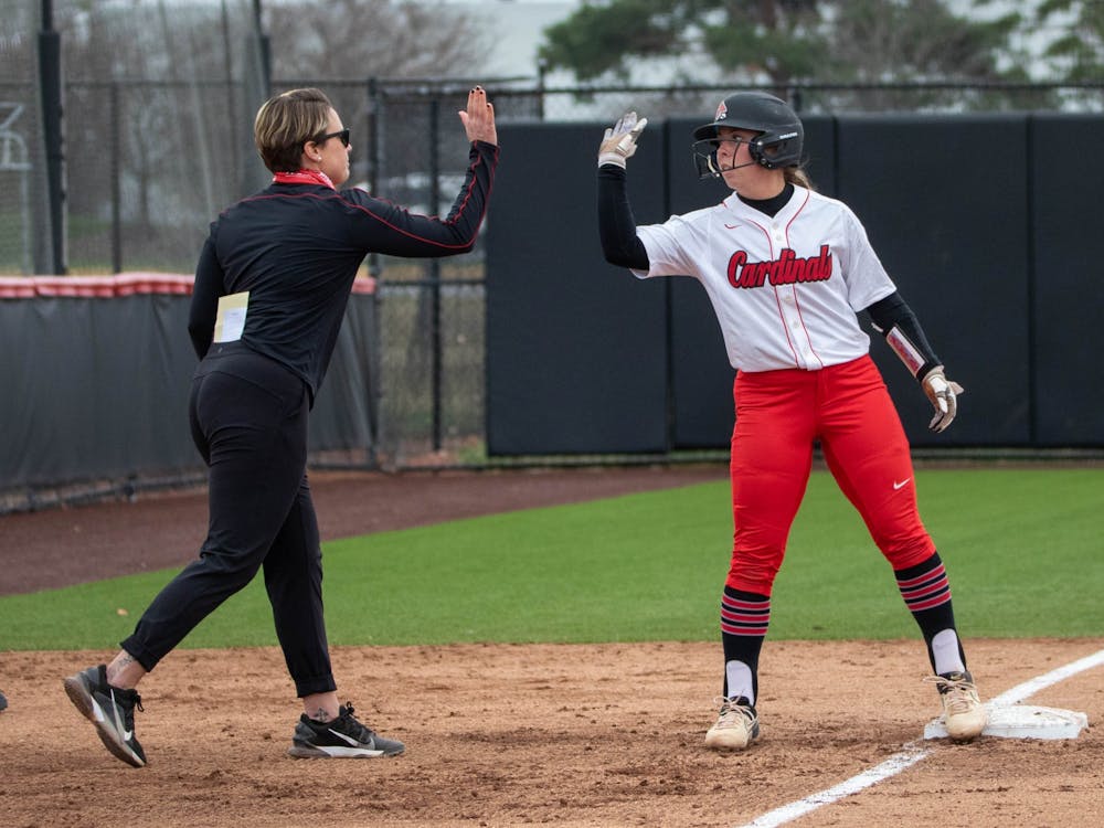 Head coach Lacy Wood celebrates with sophomore infielder Haley Wynn after a hit that got three runners to home March 26, 2021, at the Softball Field at First Merchants Ballpark Complex. The Cardinals won 8-6 against the Falcons. Jaden Whiteman, DN