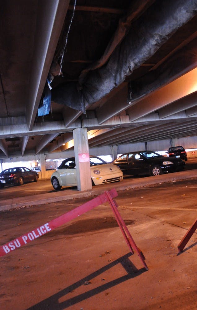 Tarps and police blockers protect people from parking in places where debris from construction could fall on their cars. Spots were blocked off after routine maintenance. DN PHOTO ASHLEY DOWNING 