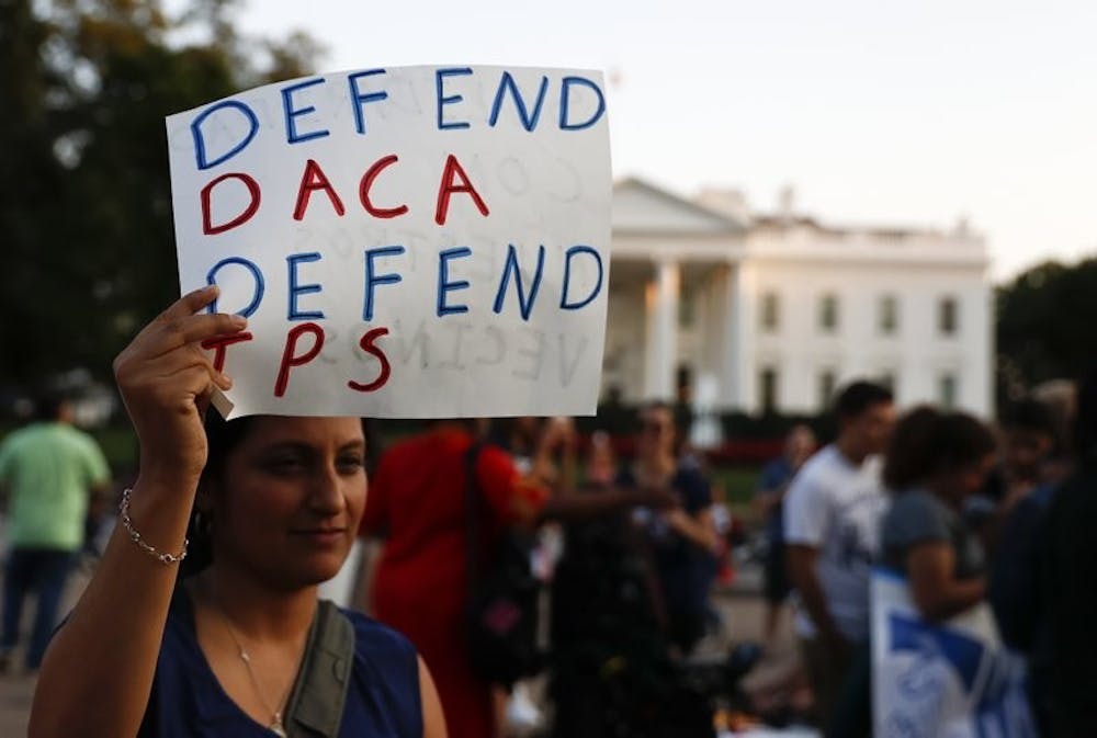 <p>A woman holds up a sign that reads "Defend DACA Defend TPS" during a rally supporting Deferred Action for Childhood Arrivals, or DACA, outside the White House in Washington, Monday, Sept. 4, 2017. <strong>AP Photo/Carolyn Kaster, Photo Provided</strong></p>