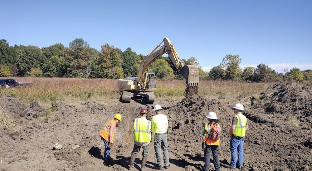 <p>Instructors and participants watch as a dam is dug by an excavator at Cooper Farm Property Oct. 1, 2022. This dam is a part of a wetland restoration project where Ball State students were involved in the restoration. <strong>John Taylor, Photos Provided</strong></p>