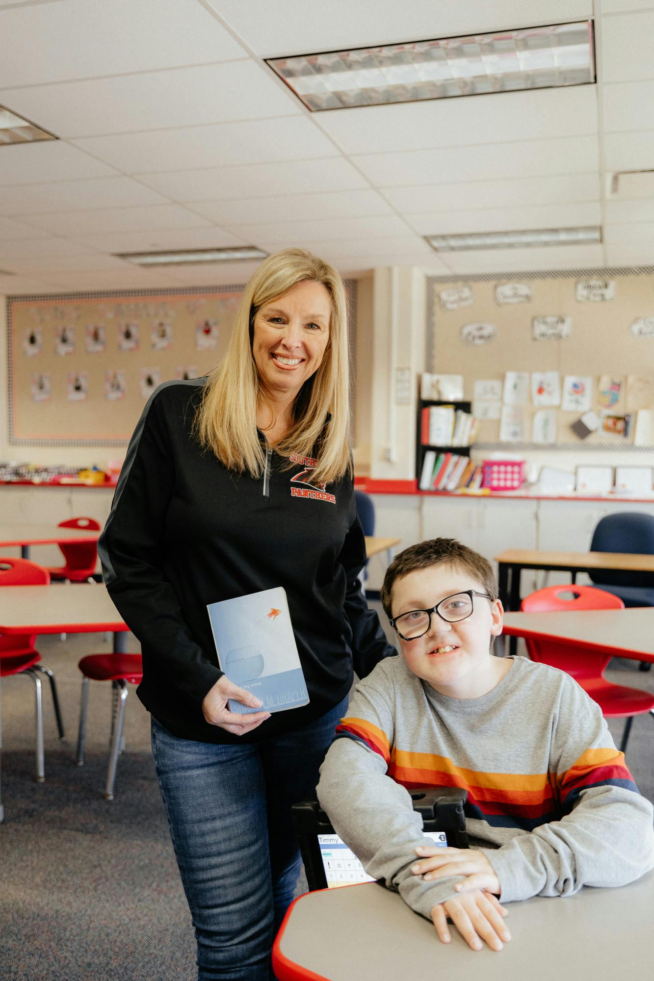 Southside Middle School Special Education Teacher Mrs. Tammy Greenwell (left) and student Timmy (right) smile as they show off the book Mrs. Greenwell reads to her class March 21 at Southside Middle School. Kaylee Kern DN