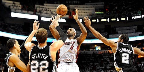 The Miami Heat’s LeBron James takes the shot between three San Antonio Spurs players in Game 2 of the NBA Finals at the American Airlines Arena in Miami, Fla., on Sunday. MCT PHOTO