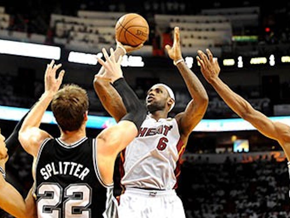 The Miami Heat’s LeBron James takes the shot between three San Antonio Spurs players in Game 2 of the NBA Finals at the American Airlines Arena in Miami, Fla., on Sunday. MCT PHOTO