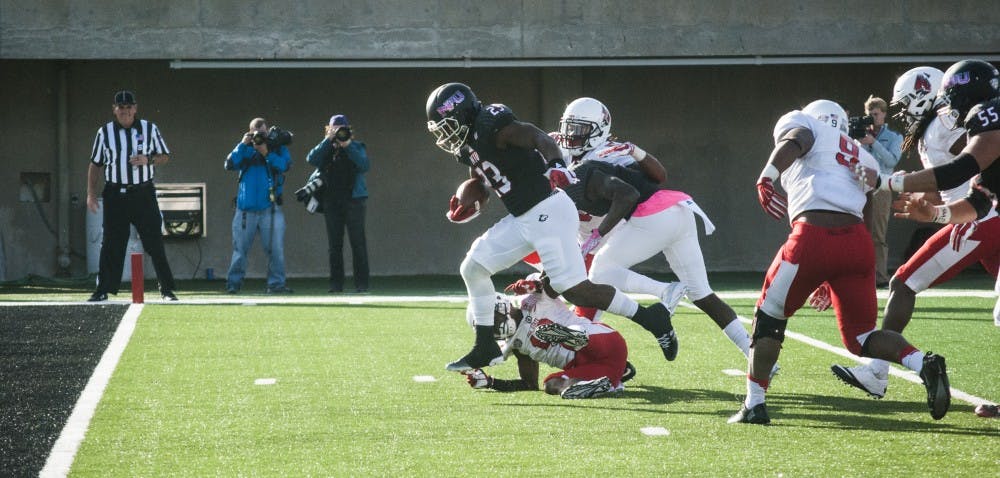 Cardinal defensive back David Moore is bowled over by Northern Illinois running back Jordan Huff, who scored a touchdown on the run to increase NIU's lead to 28-13 in the second quarter. DN PHOTO COLIN GRYLLS