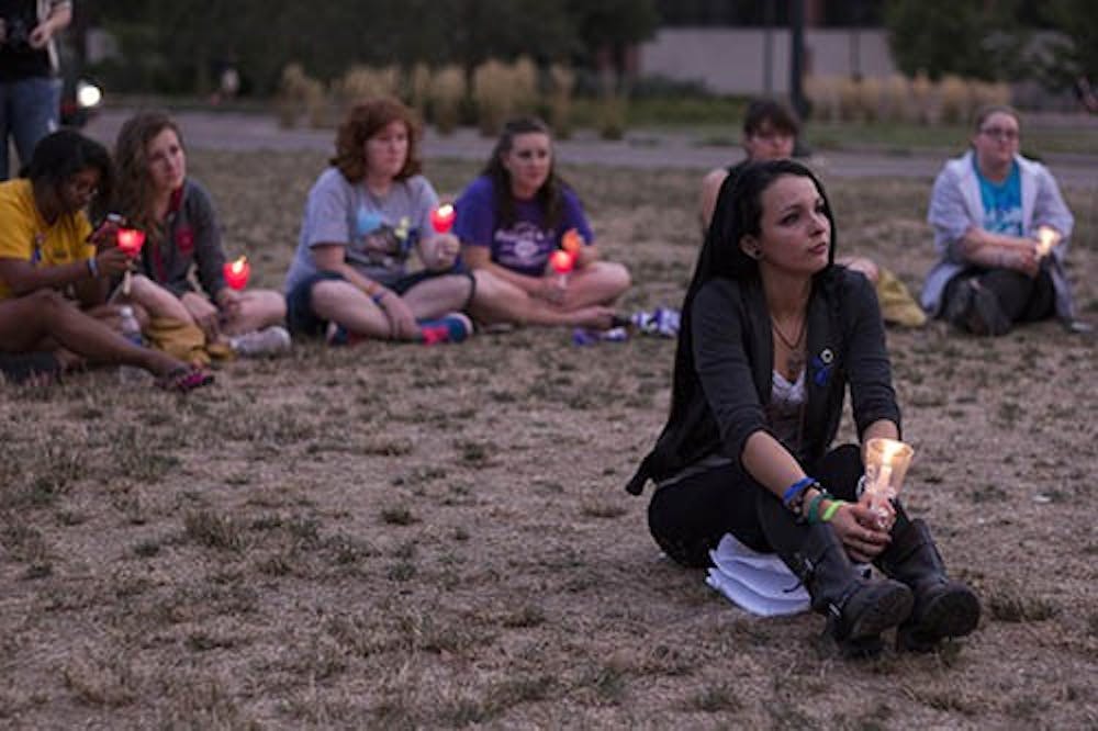 Carmen Diaz, a senior social work major, listens to a victim’s story at the Suicide Awareness Candlelight Vigil on Sept. 10th. The vigil honored victims and survivors of suicide and those with depression. DN PHOTO EMMA ROGERS