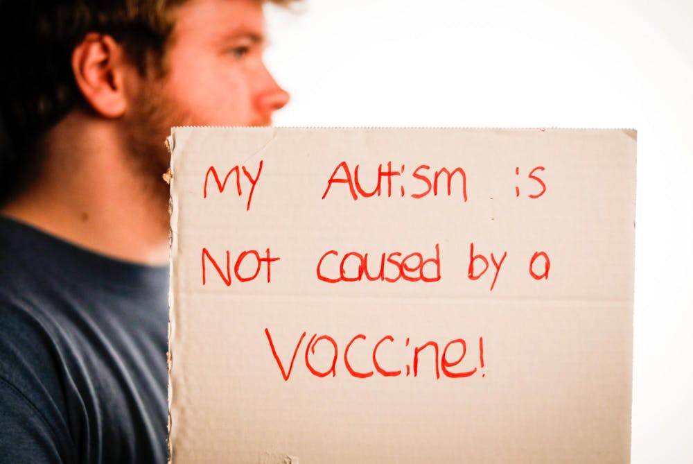 Jacob Rodgers holds a sign reading “My autism is not caused by a vaccine!” Oct. 14 in the Arts and Journalism Building. A survey from the Annenberg Public Policy Center showed an increase in those who believe that the MMR vaccine may cause autism from 9 percent in 2021 to 12 percent in 2023. Andrew Berger, DN


