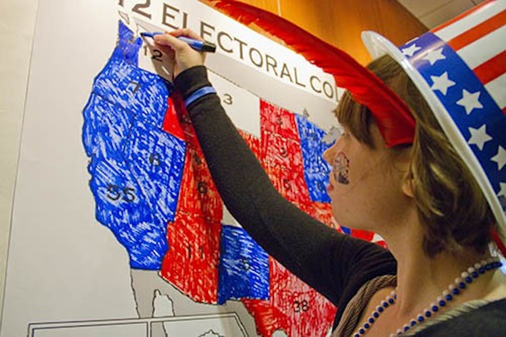 Callie Johnson a freshman Actuarial Science and Japanese major colors in an election map in DeHority on Election night. Many students attended watch parties to view the results as they came in for the 2012 election. DN FILE PHOTO EMMA FLYNN