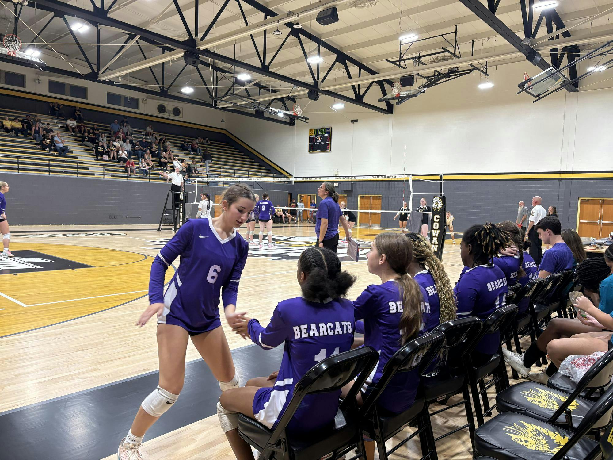 After being subbed out, Amaya Zolman gives her teammates on the bench  words of encouragement during a tense match for Muncie’s Lady Bearcats. The team finished the game strong, going 3-1 in sets against Cowan’s Blackhawks. Photo by Madison Ward