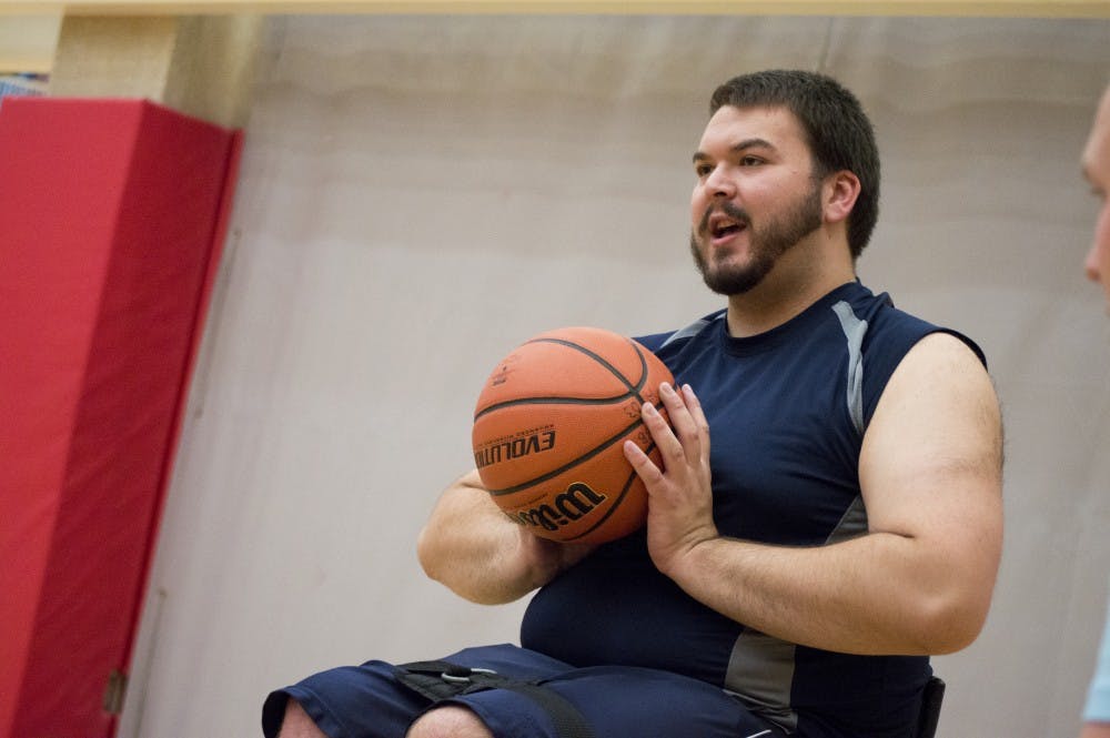 Junior chemistry and pre med major Matthew Marshall explains to the new players how to pass, dribble, and shoot while playing wheelchair basketball on Sept. 23 at the Jo Ann Gora Student Recreation and Health Center. DN PHOTO ALAINA JAYE HALSEY