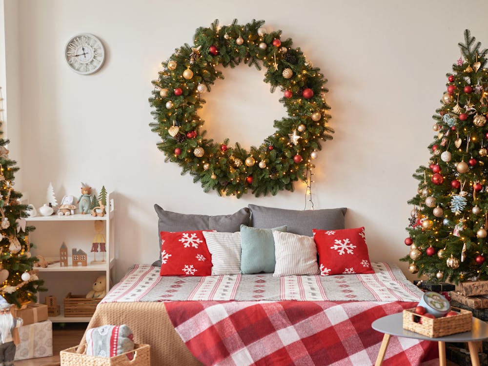 Vacation Rentals. Interior apartment. Christmas bedroom. Bed against background of Christmas tree and wreath. New Year's Eve celebration at home