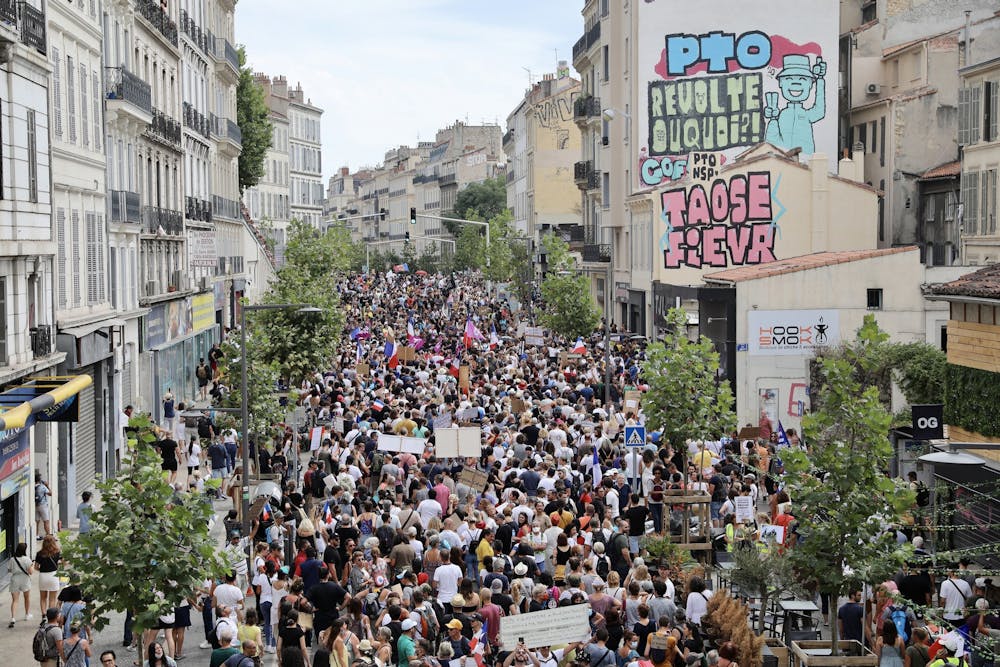 ProtestErs hold up banners and placards during a nationwide protest against France's new COVID-19 health pass on Aug. 7, 2021, in Marseille, France. (Roger Anis/Getty Images/TNS)