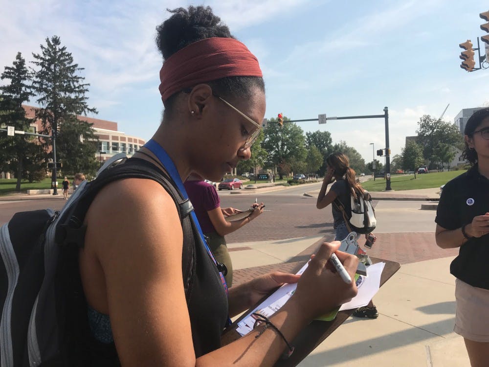 <p>Melissa Booth, sophomore fashion merchandising major, answering the question, "How do we achieve a more peaceful future?" on a paper square for #WordsMatterBSU Sept. 21 at the Scramble Light. Booth said understanding people's different perspectives will allow people to "mutually coexist" in response to the question. <strong>Hannah Gunnell, DN</strong> &nbsp;</p>