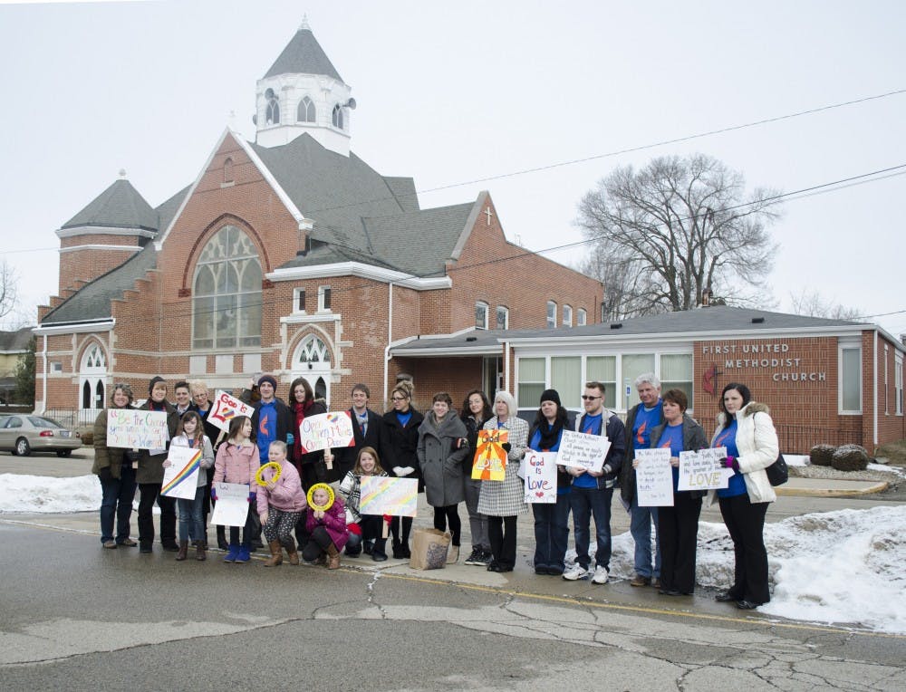 A group of protesters stand outside of the First Methodist Church of Alexandria before starting the protest on Sunday. DN PHOTO BREANNA DAUGHERTY 