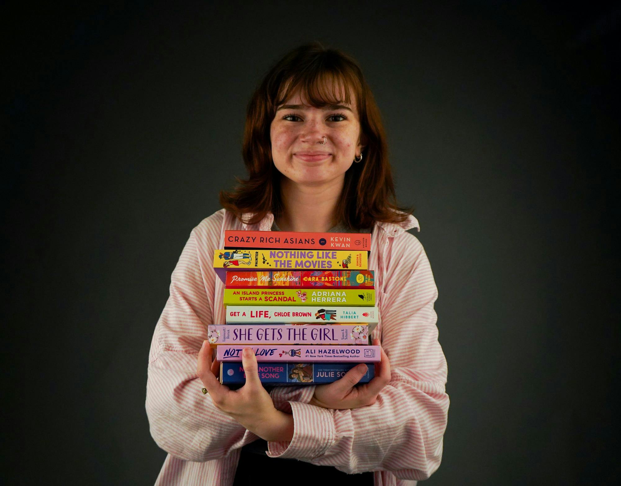 Linnea Sudquist poses with some of her favorite romance books Sept. 18 in the Art and Journalism building. Isabella Kemper, DN