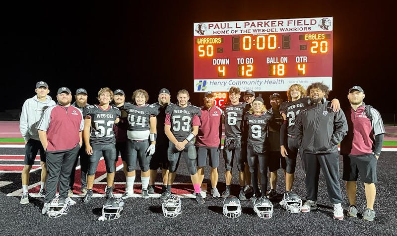 The Wes-Del coaching staff standing with seniors Oct. 18 after defeating Cambridge City Lincoln. The final score of 50-20 marks the Warriors first winning regular season since 2016. Zach Carter, DN 