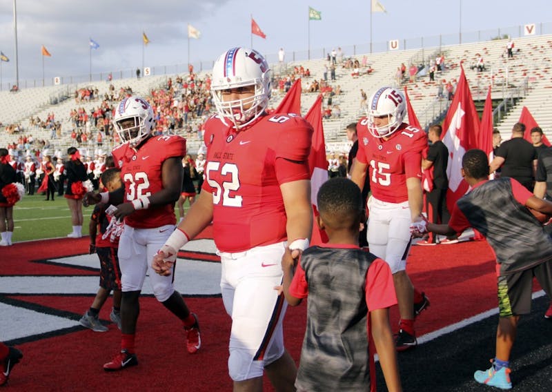 Ball State Football captains redshirt senior Jeremiah Jackson (32), redshirt senior Fred Schroeder (52) and redshirt junior Riley Neal (15) high five a young Ball State fan before the coin toss for the Cardinals' game against Central Connecticut State Thursday, Aug. 30, 2018, at Scheumann Stadium. &nbsp;Paige Grider, DN