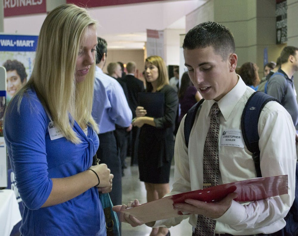 Senior telecommunications major Alexis Kabacinksi and fifth-year senior telecommunications major Christopher Schaler discuss their resumes with one another Wednesday afternoon. Many businesses were accepting resumes at the Career Fair. DN PHOTO SARAH COLE