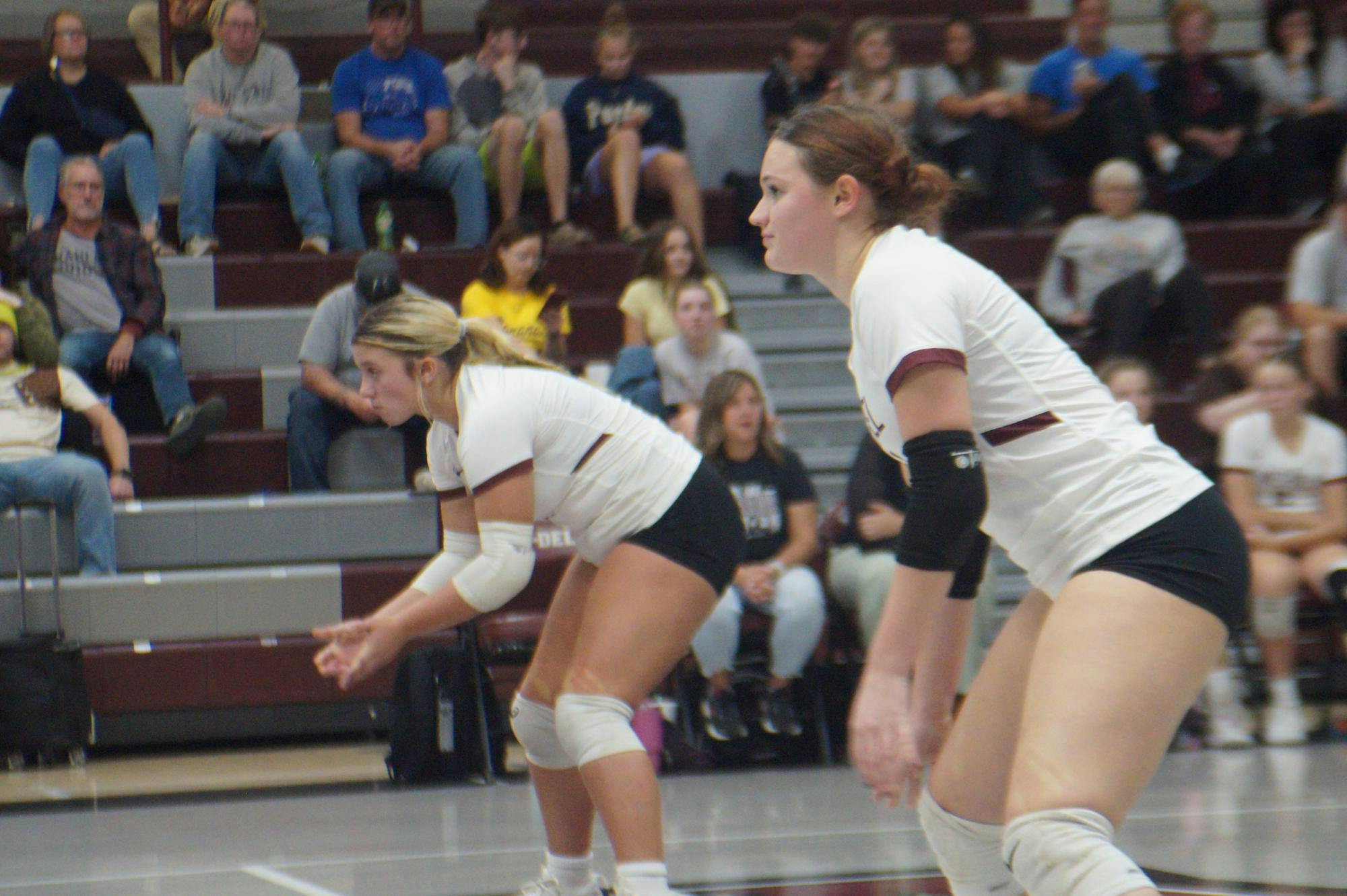 Seniors Ansley Draper, 4, and KyLynn New, 1, prepare themselves to defend a serve. They helped their team score 22 points in the second set, almost taking it for the Warriors. PHOTO BY NICK ROARK
