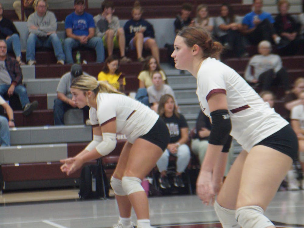 Seniors Ansley Draper, 4, and KyLynn New, 1, prepare themselves to defend a serve. They helped their team score 22 points in the second set, almost taking it for the Warriors. PHOTO BY NICK ROARK