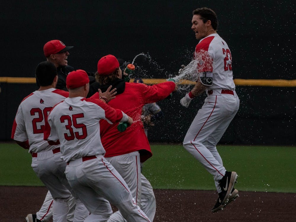 The Cardinals rush the field to meet then-junior Ross Messina after his game-winning hit against Kent State March 31, 2019, at Ball Diamond at First Merchants Ball Park Complex. The game went 13 innings before the Cardinals came out on top, 9-8. Rebecca Slezak, DN