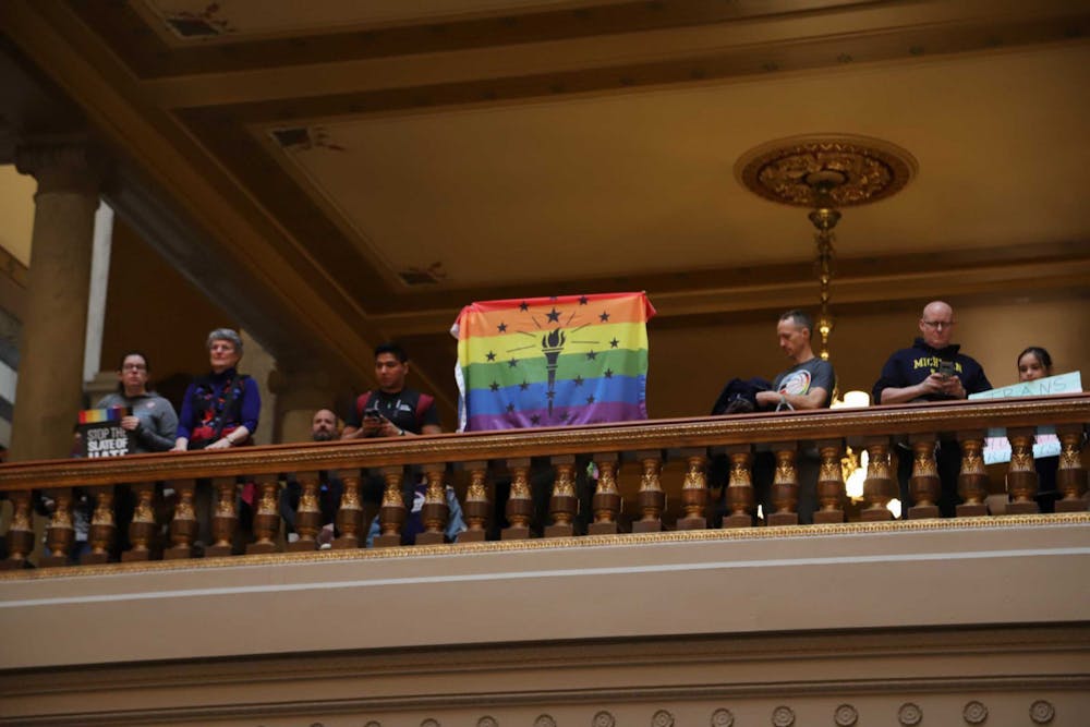 Attendee of the ACLU Rally to Protect Trans Youth holds up Indiana state flag with a pride background at the Indiana State House on April 1. The rally was held in relation to SB 480. Olivia Ground, DN 