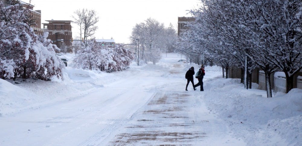 Freshman nursing major Hope Eckland and freshman business major Karie Wissel cross McKinley Avenue on Jan. 6. Eckland and Wissel were going into the bookstore in the Art and Journalism Building to pick up their books for the semester. DN PHOTO BREANNA DAUGHERTY 