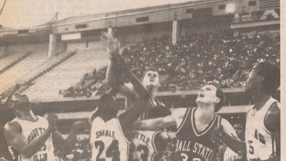 Greg Miller puts up a shot as Roman Muller fights for rebounding position in a 1989 game. Miller and Muller were two of nine seniors on the 1990 team that went to the Sweet 16. This photo was printed in the March 21, 1989 Daily News edition.