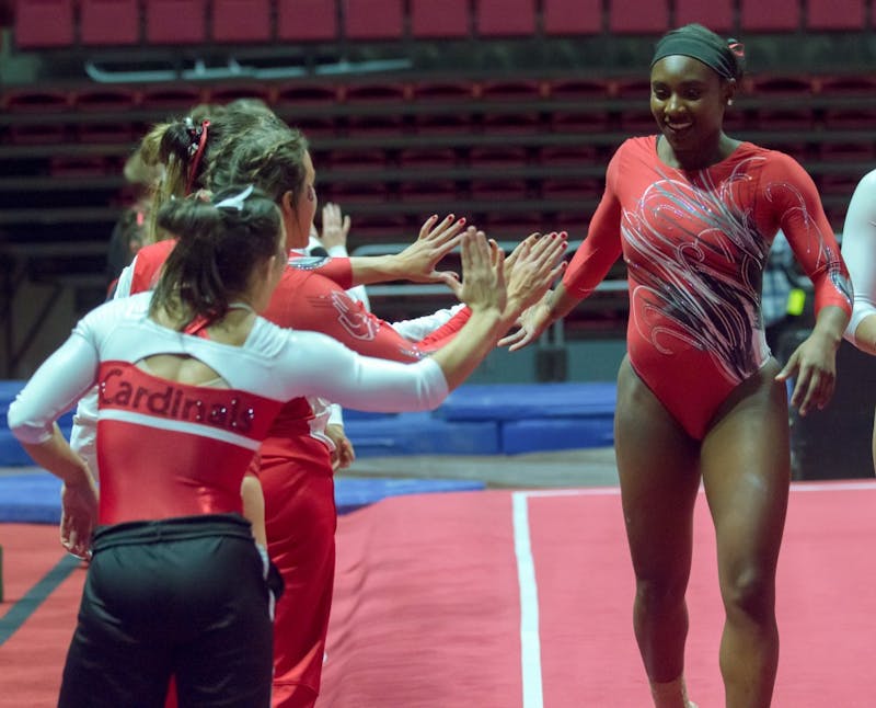Freshman Tia Kiaku high fives her teammates after completing her floor routine during the Red vs. White meet on Dec. 4 in John E. Worthen Arena. Teri Lightning Jr., DN