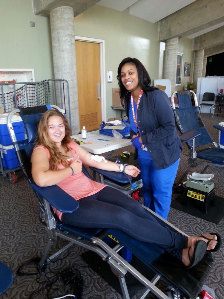 Ball State student Crystal Nichols poses for a photo while giving blood with the help of Indiana Blood Center blood technician Evadnie Turner on Sept. 9 at Pruis Hall as part of the Live to Give event. PHOTO PROVIDED BY  LUCY WEHKING