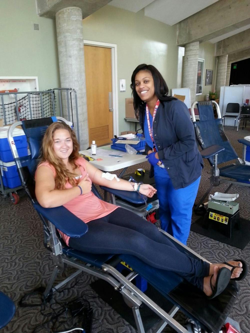 <p><strong>Ball State student Crystal Nichols</strong> poses for a photo while giving blood with the help of Indiana Blood Center blood technician Evadnie Turner on Sept. 9 at Pruis Hall as part of the Live to Give event. <em>PHOTO PROVIDED BY  LUCY WEHKING</em></p>