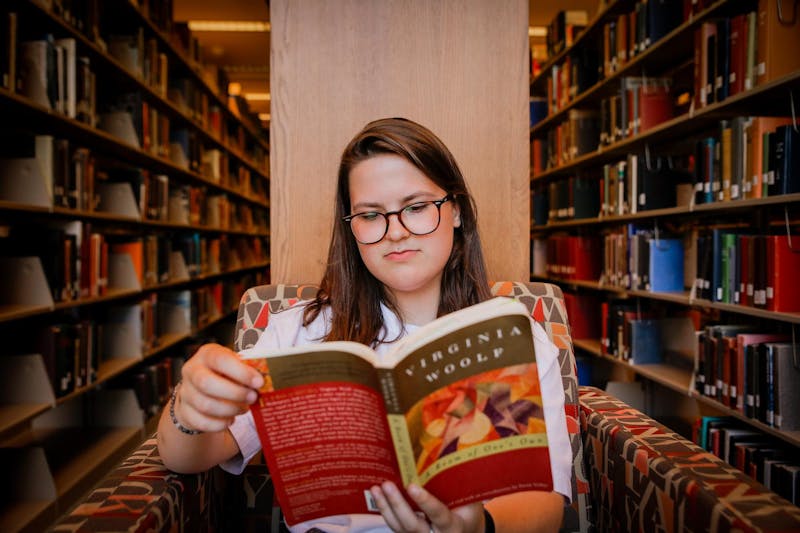 Trinity Rea reads one of their books Sept. 16 in Bracken Libary. Rea says books gave them a place to escape while they dealt with internal and outward struggles in their own life. Andrew Berger, DN 
