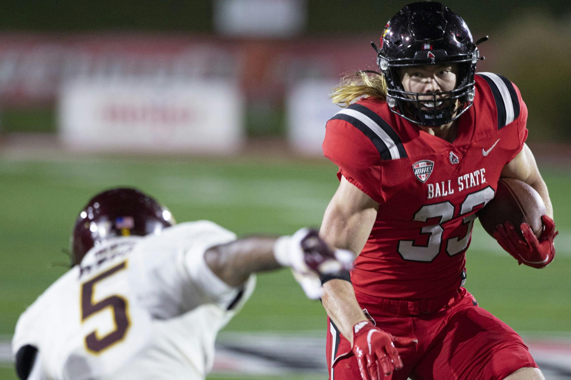 Cardinals freshman running back Carson Steele looks to hurdle Chippewas junior defensive back Devonni Reed Nov. 17, 2021, at Scheumann Stadium. The Cardinals lost to the Chippewas 37-17. Jacob Musselman, DN