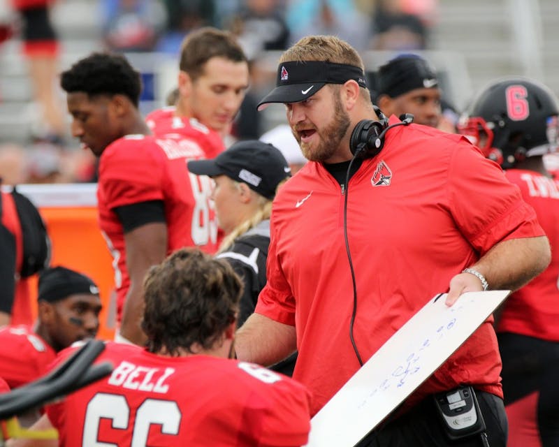 Offensive line coach Kyle DeVan goes over a play during the Cardinals’ game against Northern Illinois on Oct. 1 in Scheumann Stadium. Ball State lost 31 to 24. Paige Grider// DN