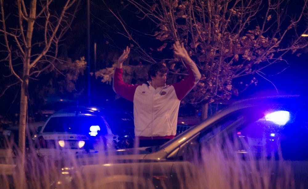 Aric Fickert, a sophomore exercise science major, speaks to police about what he knew after an officer's gun accidentally discharged a few moments earlier. Fickert was released immediately after questioning. DN PHOTO COREY OHLENKAMP