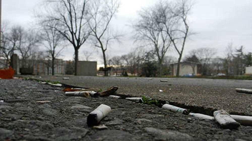 Cigarette buds scatter the ground at the smoking area by the Studebaker East Complex. The new ban will force the students, faculty and staff who use this area to move off campus to smoke. DN FILE PHOTO EMMA FLYNN