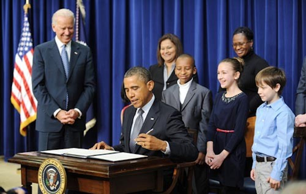 President Barack Obama signs a series of executive orders about his administration’s new gun law proposals as Vice President Joe Biden, Hinna Zeejah, Taejah Goode, Julia Stokes and Grant Fritz — children who wrote letters to the White House about gun violence — look on. The executive orders come in the wake of the discussion about gun control brought about by the Sandy Hook shooting. MCT PHOTO