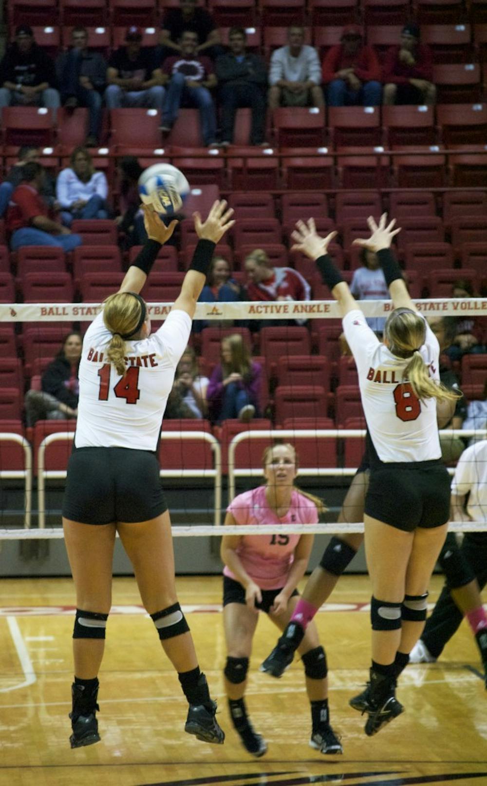 Senior middle hitter Kelly Hopkins and freshman outside hitter Jessica Lindsey jump up to block a ball from opponent Eastern Michigan on Oct. 3 at Worthen Arena. DN PHOTO SAMANTHA BRAMMER
