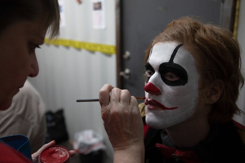 Jodie Morgan, the manager of Indy Scream Park's makeup trailer, works on painting lips onto a Midway actor's face for their costume. Indy Scream Park's makeup artists work for two hours each day before the park opens to complete the actor's full look. Jacob Musselman, DN