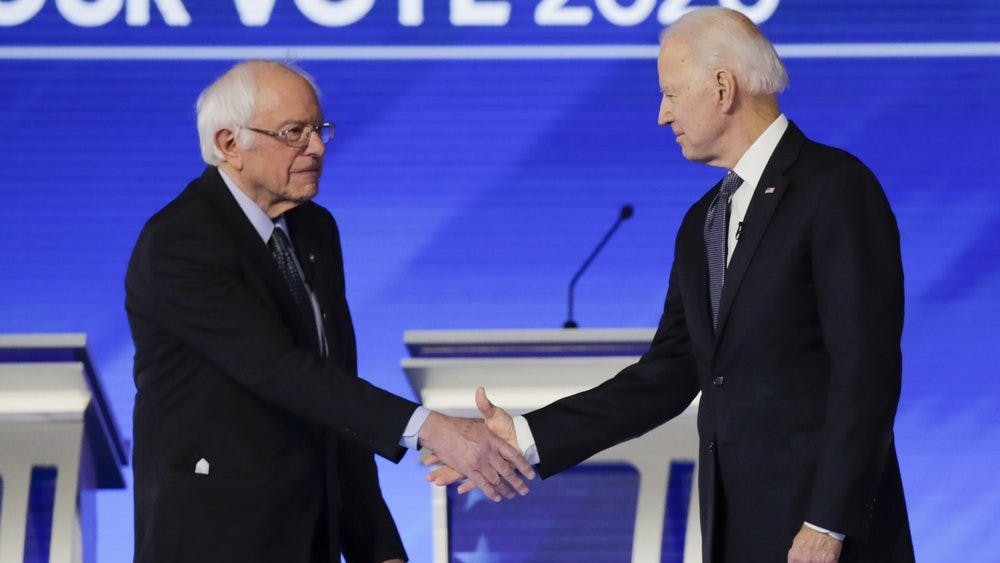 Democratic presidential candidates Sen. Bernie Sanders, I-Vt., left, and former Vice President Joe Biden, shake hands on stage Friday, Feb. 7, 2020, before the start of a Democratic presidential primary debate hosted by ABC News, Apple News, and WMUR-TV at Saint Anselm College in Manchester, N.H. (AP Photo/Charles Krupa)