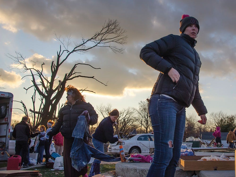 Volunteers and residents continue to shovel debris and gather anything salvageable from one of several destroyed homes near Home Ave. in Kokomo, Ind. DN PHOTO COREY OHLENKAMP