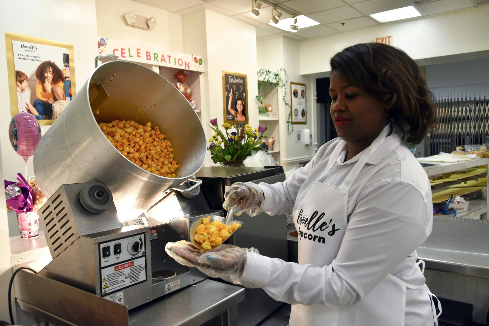 Danielle’s Popcorn owner Danielle Jernigan holds out popcorn from the popcorn tumbler on March 22 in Muncie Mall. Ella Howell, DN