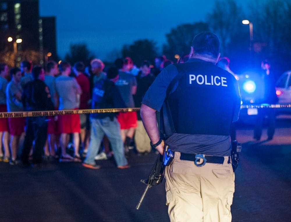 A police officer crosses across crime scene tape on Nov. 15. DN PHOTO JONATHAN MIKSANEK